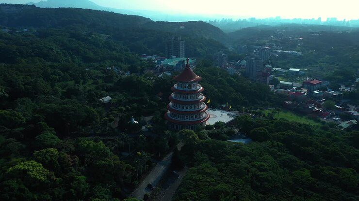 Vue aérienne montrant le temple Tianyuan dans la ville de Tamshui, entouré d'arbres forestiers verdoyants à Taïwan.