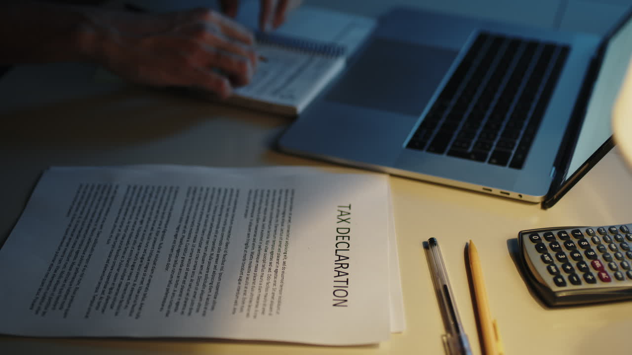 hombre haciendo la declaración de impuestos en la mesa