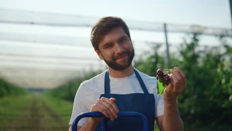 Successful-farmer-man-looking-camera-at-modern-summer-garden.-Farm-concept.