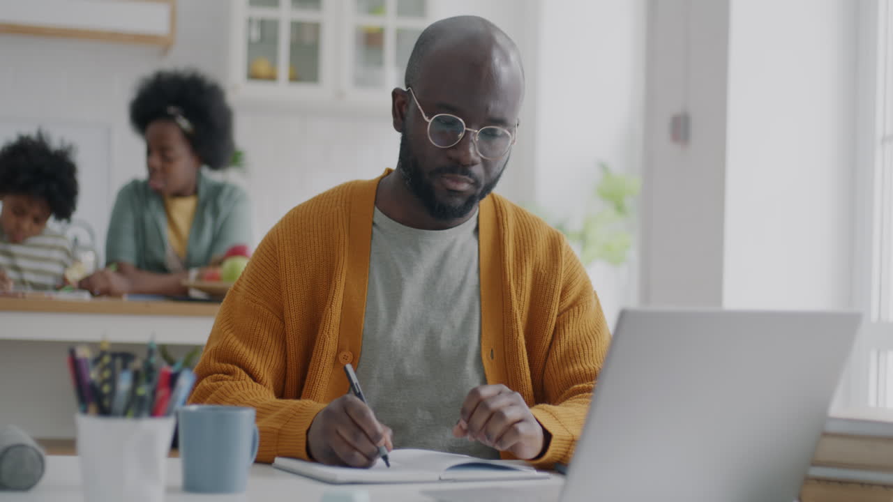 Man working from home with children in the background