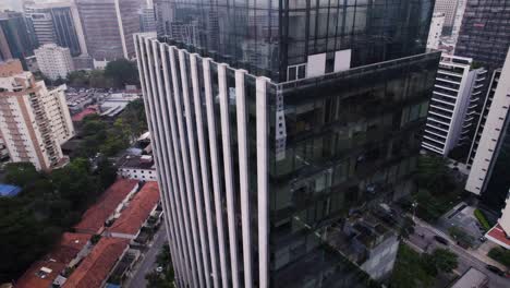 Orbital-drone-flight-over-a-corner-of-a-fancy-mirrored-business-building-in-Faria-Lima-avenue,-São-Paulo-Brazil