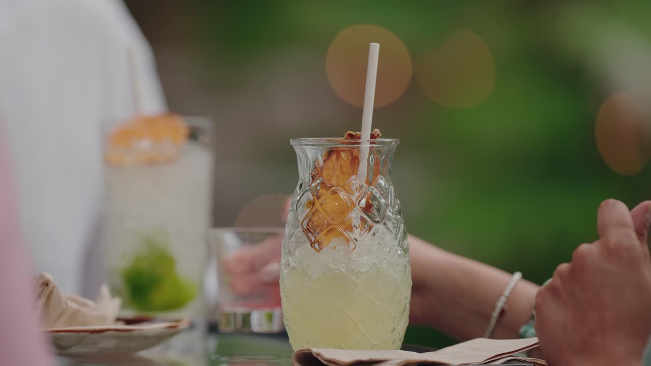 iced tropical drink with pineapple garnish served in textured glass at table