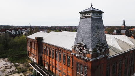 abandoned industrial building with broken windows, close up aerial ascend view