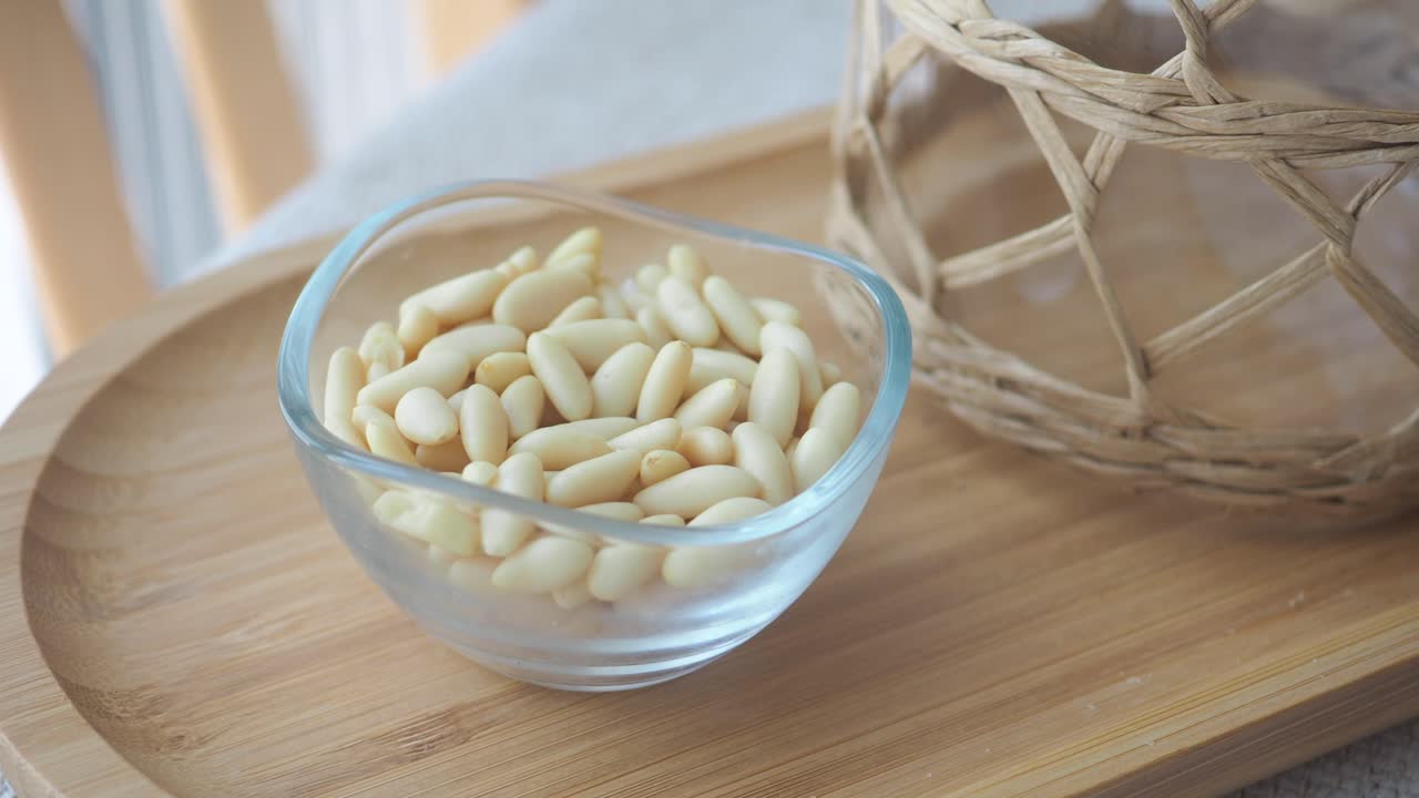 Pine Nuts in a Glass Bowl on a Wooden Tray