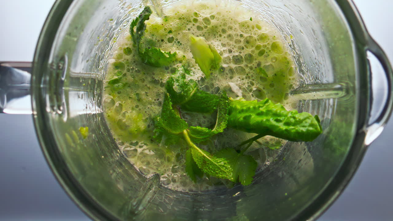 채소, 허브, 과일과 함께 블렌더에서 스무디를 준비하는 과정