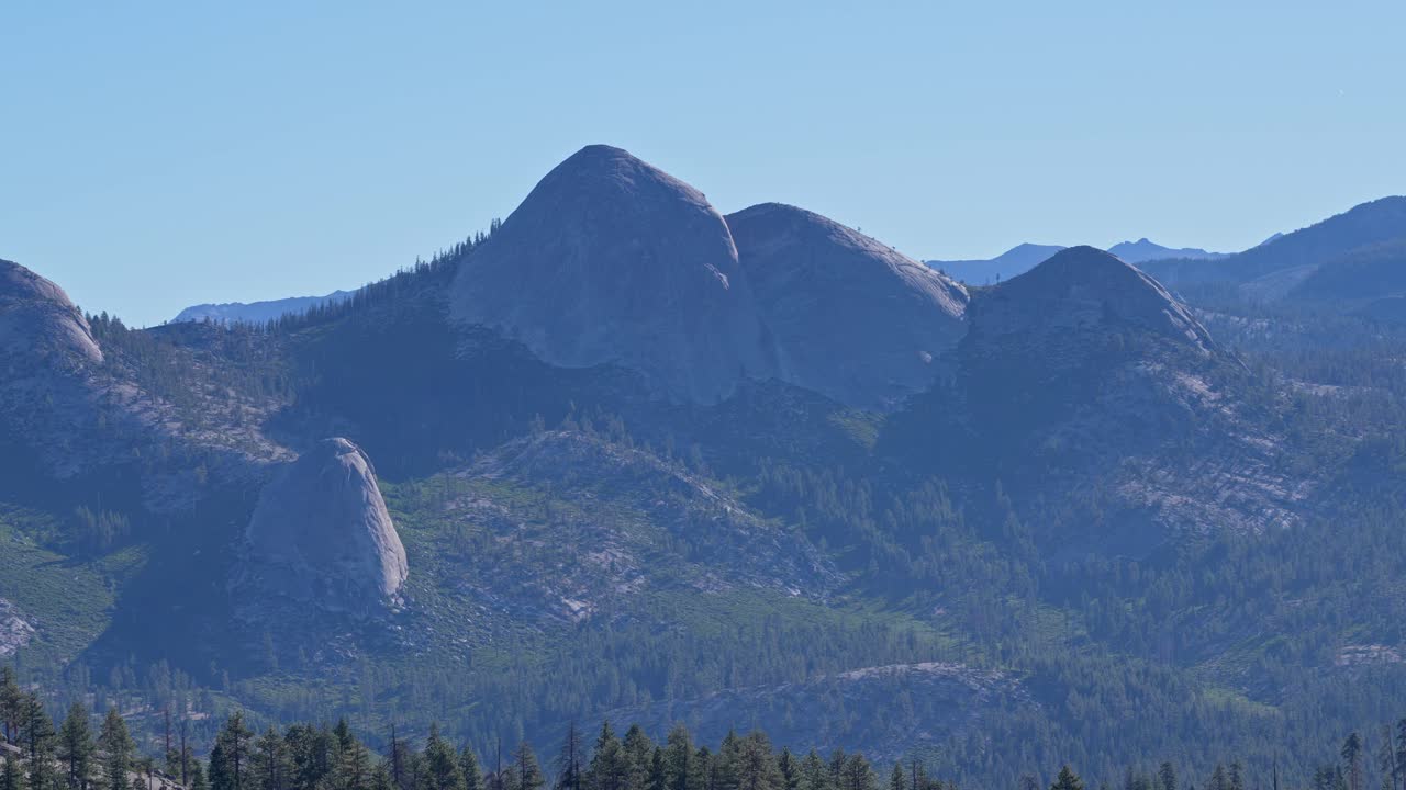 Footage featuring a zoomed pan view of the granite landscape of Yosemite National Park in California, USA. The shot highlights the rugged rock formations and natural beauty of this national park