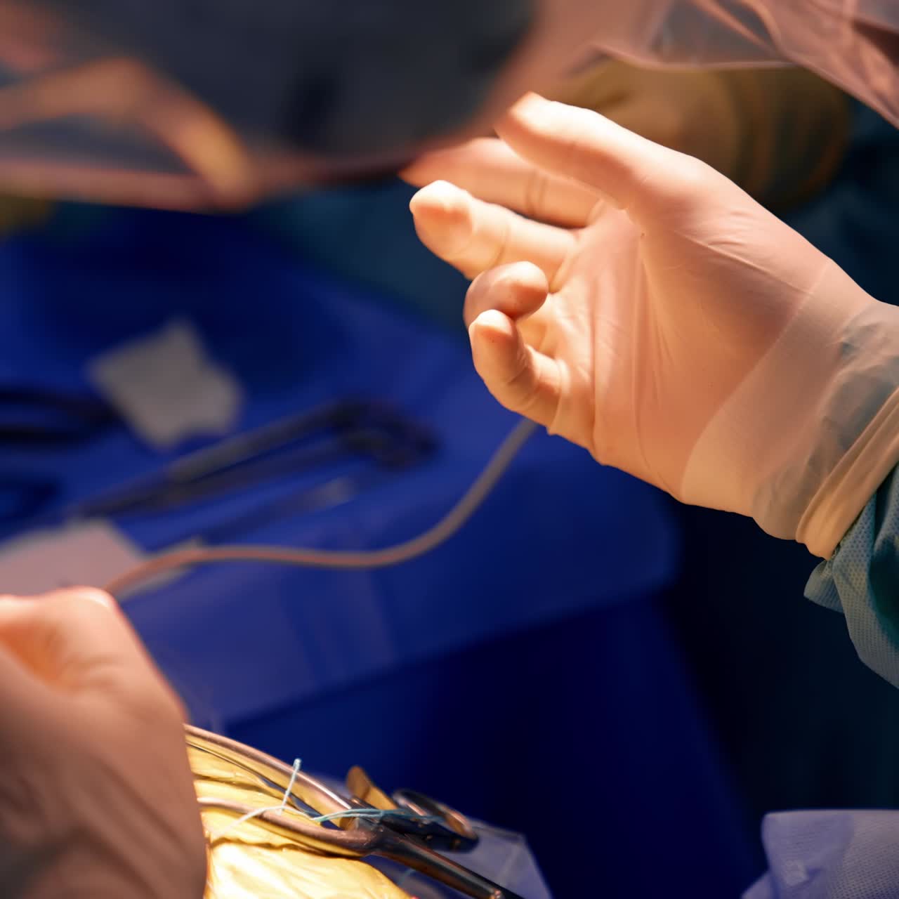 Surgeon's hand in latex gloves stretches to get a metal tool from assistant. Operational spot highlighted at neurosurgical procedure. Close up