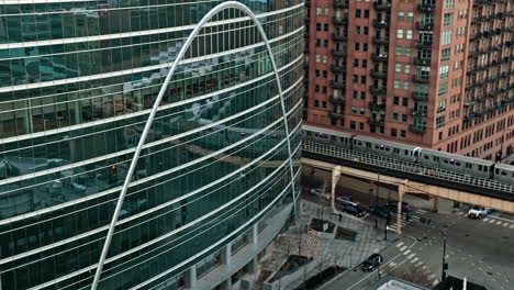 Train-moving-on-elevated-rails-in-middle-of-high-rise-in-Loop,-Chicago---Aerial-view