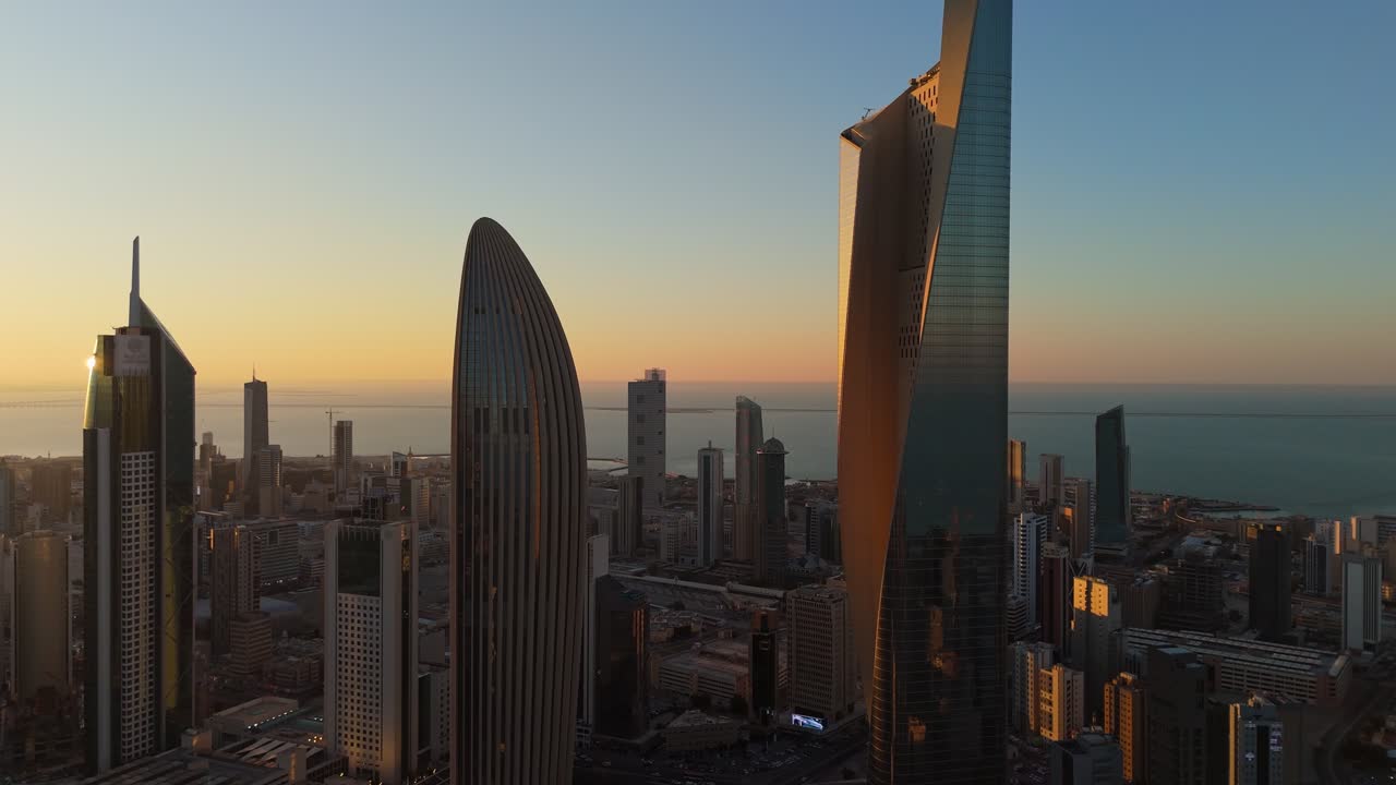 4K aerial shot of Kuwait City’s skyline at sunset with iconic skyscrapers and the Gulf horizon. Ideal for tourism, real estate, and Middle East cityscape features. Category: Travel – Urban Landscape.