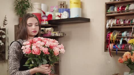 florist preparing a bouquet of pink roses