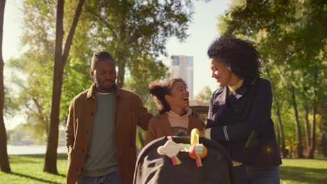 happy family talking walking together in sunny park. joyful family weekend.