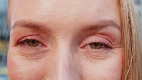 closeup macro portrait of natural happy mature attractive woman with brown eyes looking at camera