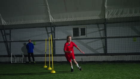 young female soccer player practicing dribbling and agility