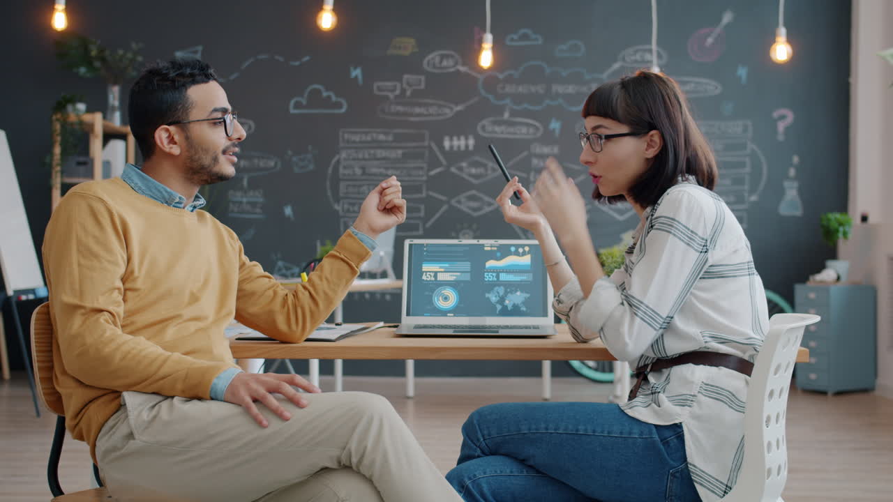 Business Colleagues Discussing Data on a Laptop in Office