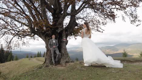 Lovely-caucasian-wedding-couple-newlyweds-family-bride-groom-stay-together-on-mountain-slope-hill