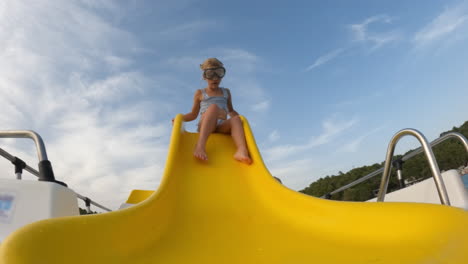 young girl having fun on a water slide in the ocean