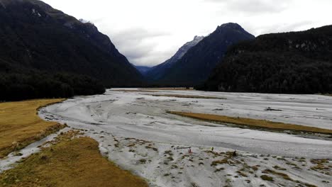 tomada aérea de un grupo de excursionistas que pasan por el valle del río dart utilizado como ubicación para el señor de los anillos