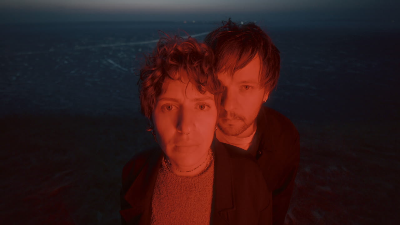 Portrait of Couple in Red Light against Frozen Lake at Night