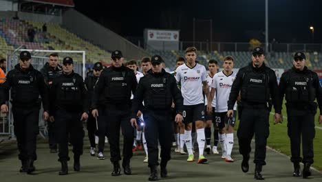 players and security personnel entering the stadium together: a unified presence in the high-stakes environment of competitive sports