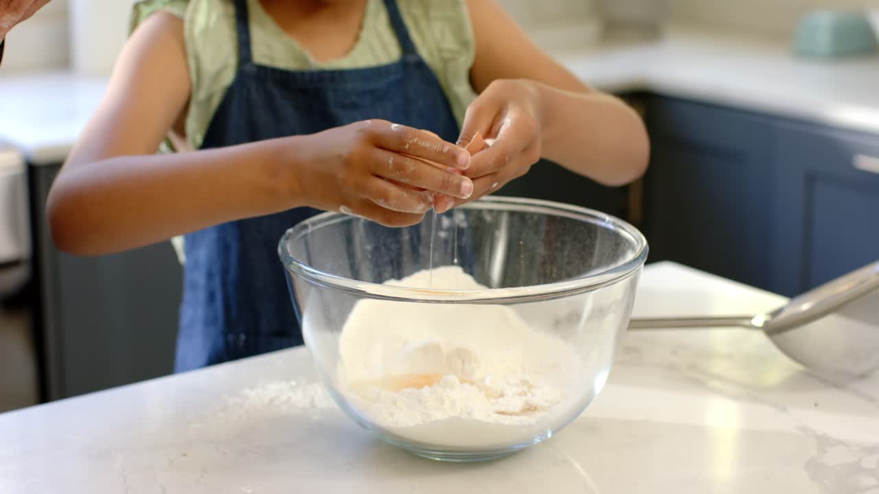 Girl tapping egg on bowl, cracking and adding yolk to flour for mixing, parent removing fragments