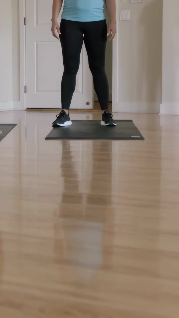 Vertical video: Shifting weight, stepping off mat, center woman walking toward door to exit in tank