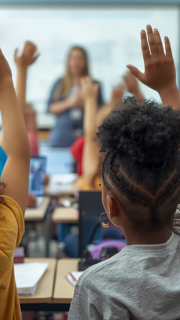 Vertical video: Elementary student raising hand after teacher question at desk, with notebooks