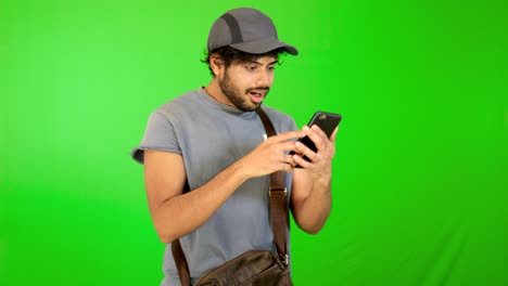 guy-using-mobile---tablet-with-green-screen-and-green-background-indian-guy-with-green-screen