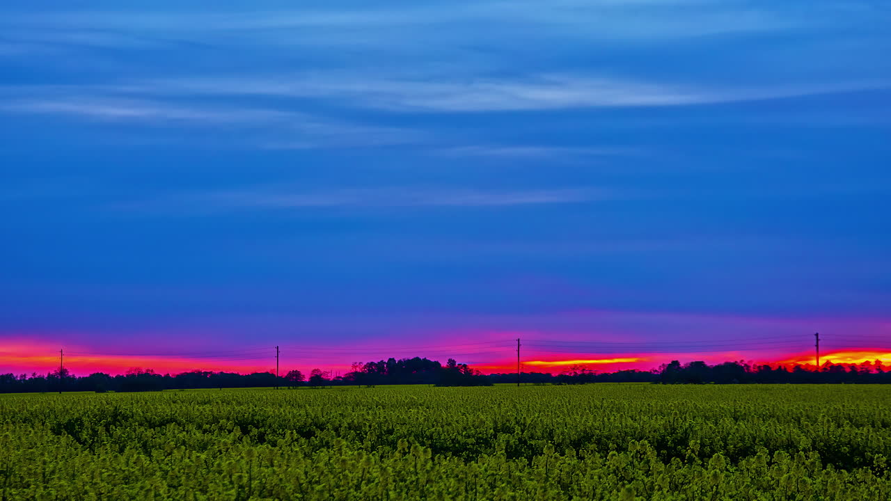 농업 풍경 위에 짙은 파란색 구름이 있는 붉은 일몰 하늘, 융합 시간 경과