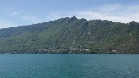 Panoramic-slow-motion-green-mountain-in-French-Alps-calm-blue-sea-at-daytime-sky