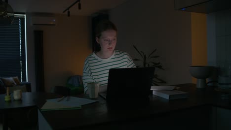 una adolescente estudiando hasta tarde en la noche.