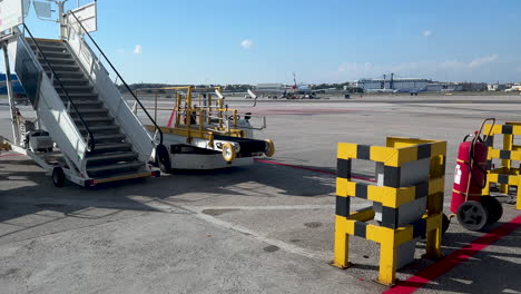 Flughafen-Jet-Brücke-Mit-Bodenunterstützungsausrüstung-Unter-Einem-Klaren-Blauen-Himmel,-Vorbereitung-Für-Den-Flugbetrieb