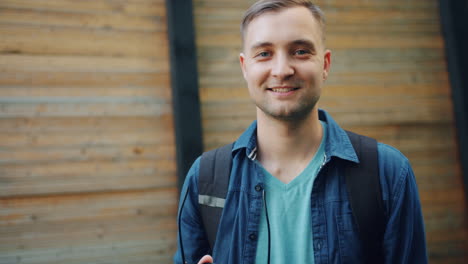 smiling man with backpack and sunglasses