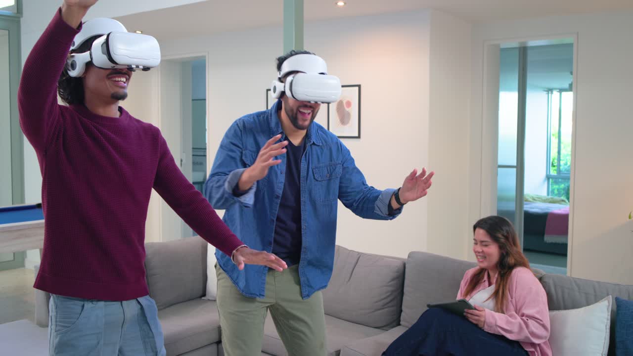 Amici che indossano visori VR, giocano a un gioco VR per divertimento, camminano, si accovacciano, ridono in casa