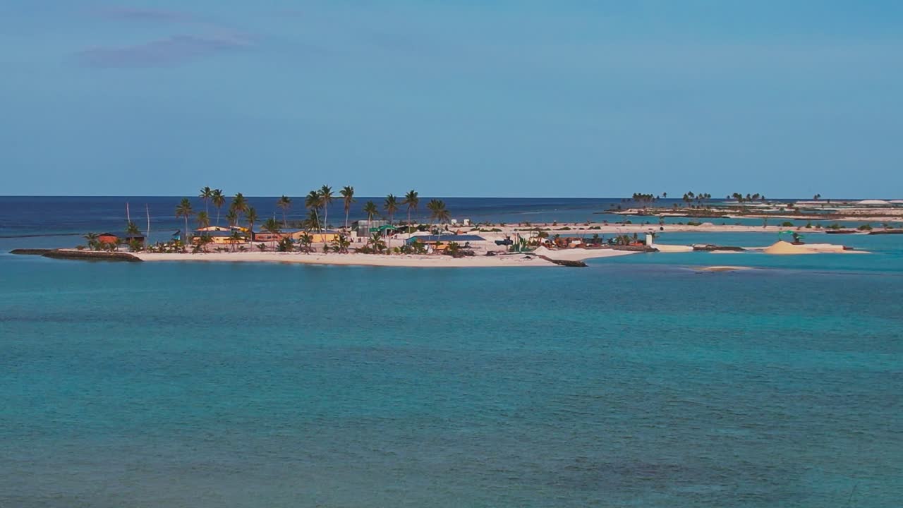 Veduta aerea di un'isola tropicale alle Maldive, con palme, spiagge di sabbia bianca e acqua cristallina color turchese, che crea una scena pittoresca e idilliaca di paradiso