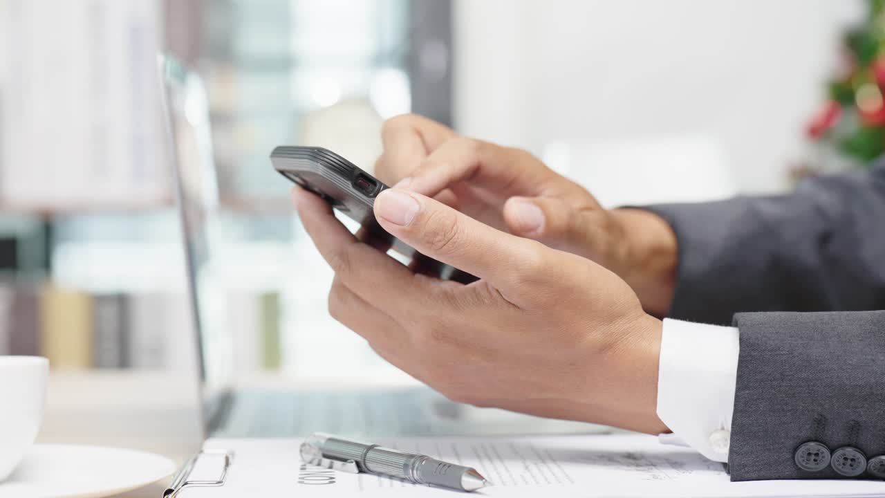 un joven empresario está teniendo una videoconferencia con los clientes a través de un teléfono inteligente conectado a internet.