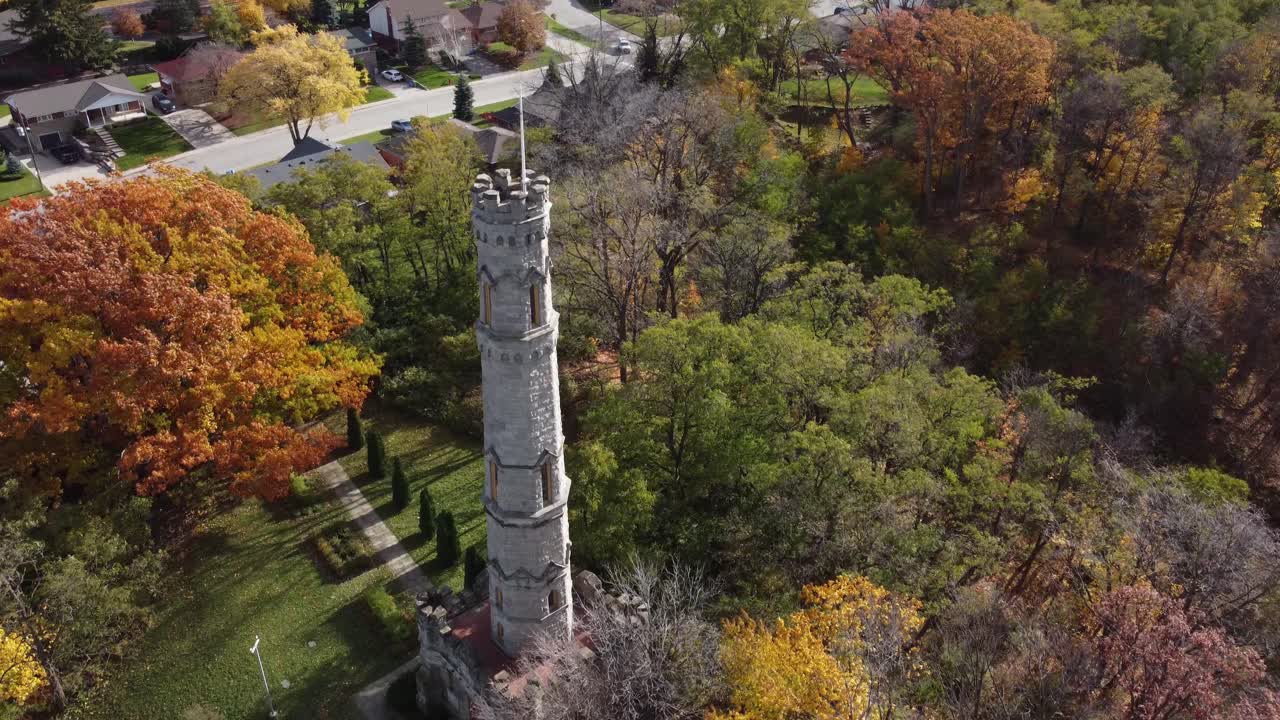 el dron gira alrededor del monumento de la casa del campo de batalla en hamilton, ontario, canadá, cierre aéreo de la torre principal de piedra en el parque