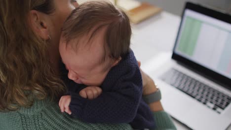 Video-De-Una-Madre-Caucásica-Trabajando-En-Una-Computadora-Portátil-Desde-Casa-Con-Un-Bebé-Recién-Nacido