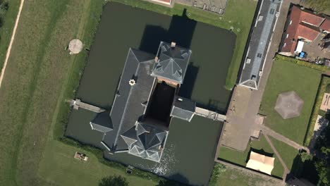 Birds-eye-view-of-monumental-UNESCO-Castle-Loevestein-near-river-Maas-in-the-Netherlands,-Aerial-shot-circling-around-castle-in-the-Netherlands