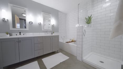 cuarto de baño moderno, luminoso y blanco, con dos lavabos, ducha y bañera en un edificio de condominios