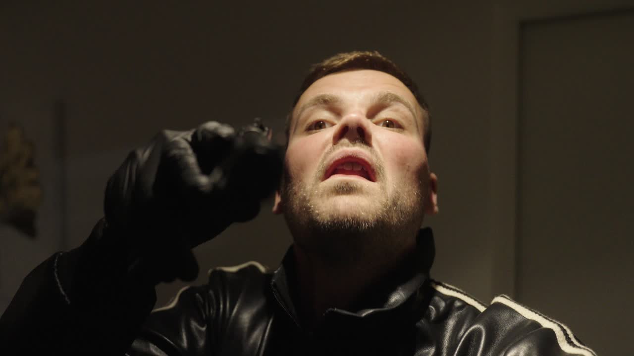 a man threatens someone with a gun in a house pov style close up