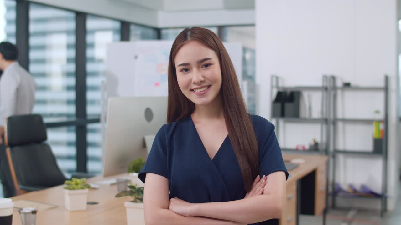 retrato de una exitosa mujer de negocios ejecutiva hermosa vestimenta casual inteligente mirando a la cámara y sonriendo, brazos cruzados en el lugar de trabajo de la oficina moderna.