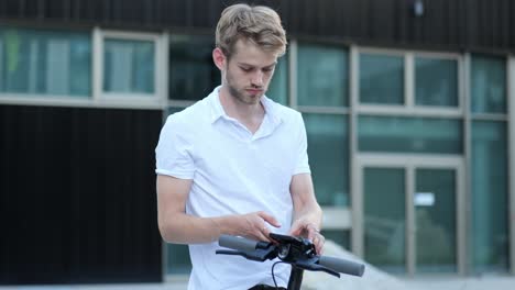 young businessman activating an e scooter with his smartphone