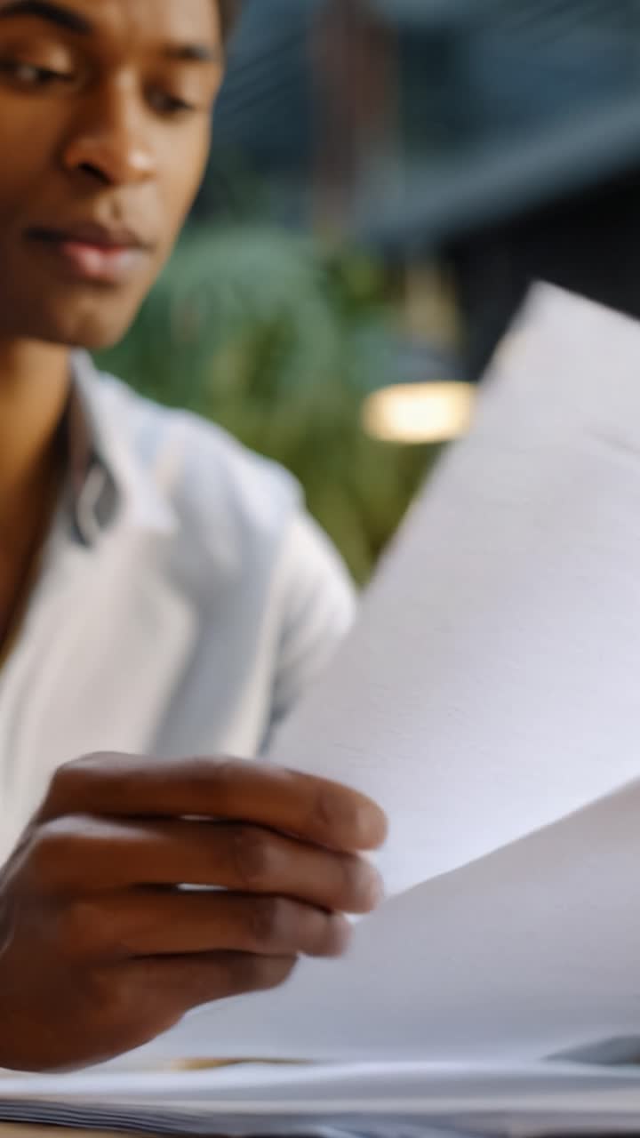 Focused examination of documents by a professional in a modern workspace, highlighting attention to detail and a commitment to thorough review and understanding