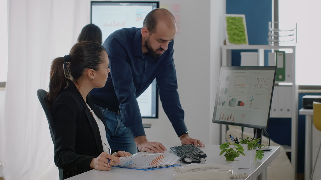 Man and woman working on business plan with data charts