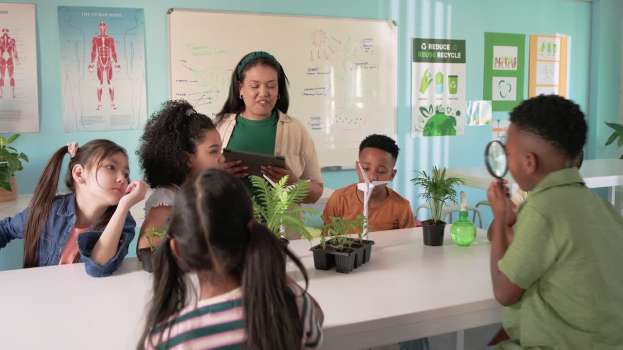 Female teacher with kids leading science, asking on tablet, guiding kid inspecting plants with lens