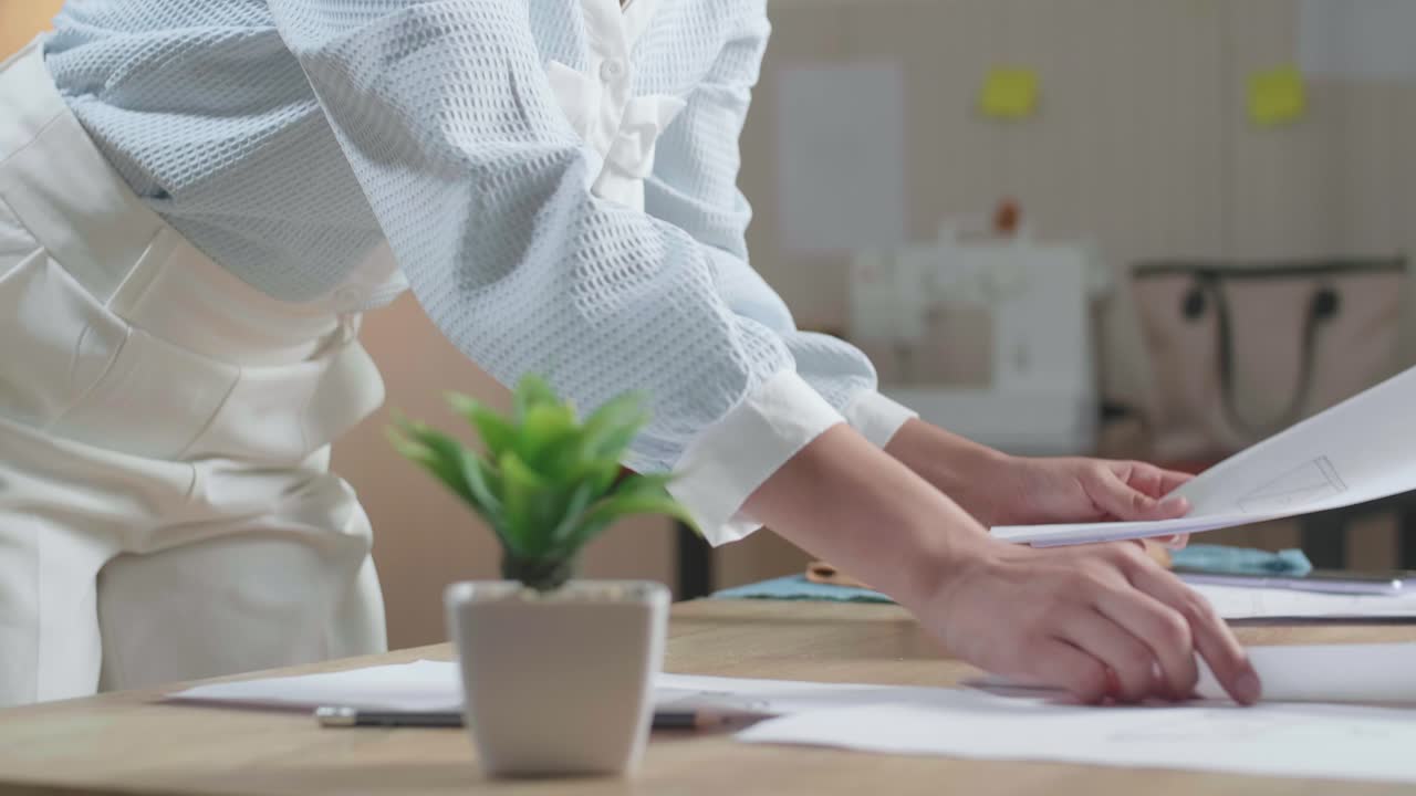 Close Up Of Asian Woman Designer Is Arranging The Layout Bond On The Table At The Office