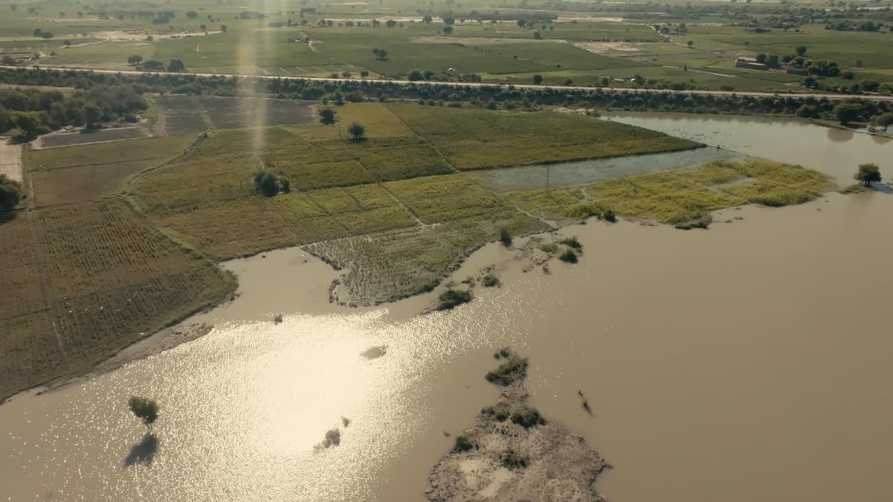 Aerial view of muddy floodwaters submerging crops and fields in Punjab, Pakistan, highlighting the impact of natural disasters on agriculture