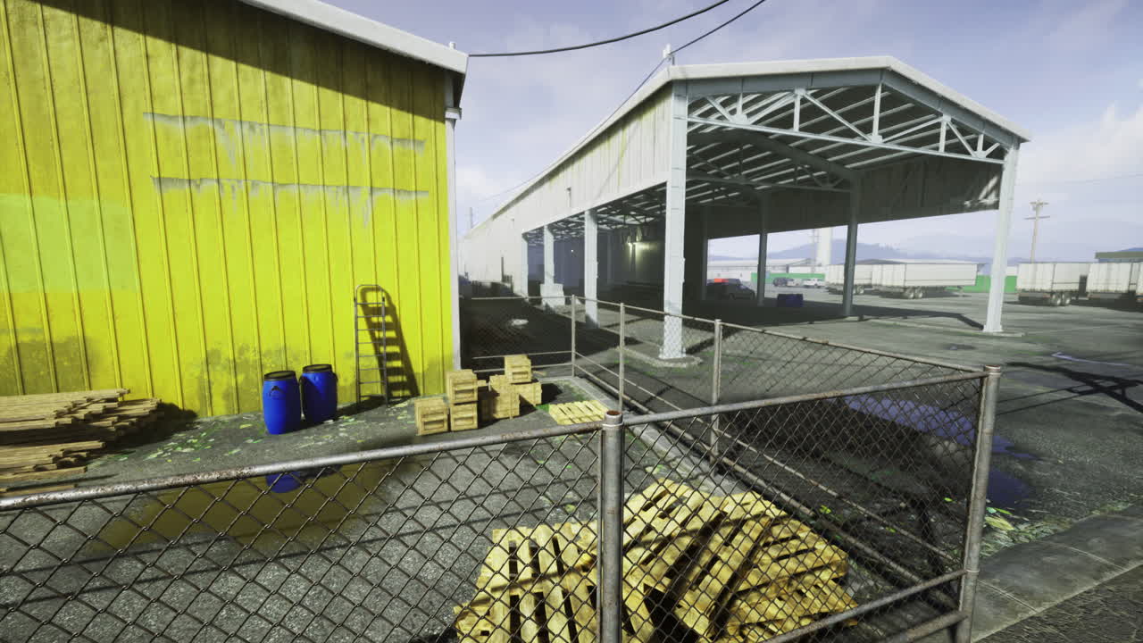 Industrial yard with wooden pallets and storage buildings at midday