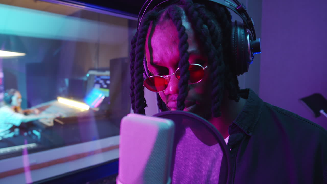 músico negro grabando una canción en el estudio