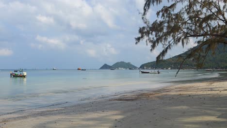 Stunning-low-tide-beach-on-tropical-island-with-fishing-boat